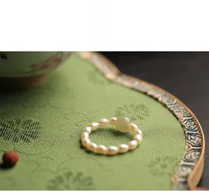 Detail of vintage Chinese style pearl ring with a translucent green jade bead center