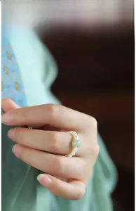 Detailed shot of Chinese vintage ring with small white pearls and a green jade bead