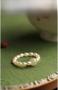 Macro detail of vintage Chinese style ring with white pearls and large green jade bead