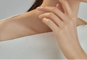 Detail shot of white ribbed off-shoulder knit top showing fine texture and neckline