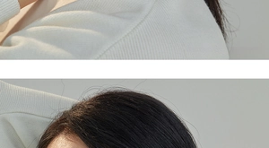 Detailed macro view of the rib-knit cream fabric and delicate shoulder seam construction