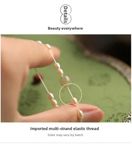 Detail of handmade pearl bracelet with green jade bead on durable elastic cord