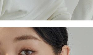 Close-up of white ribbed knit fabric texture and soft neckline detail on elegant garment