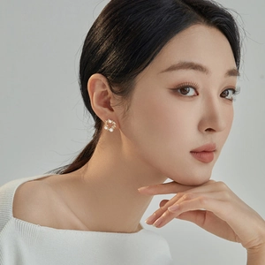 Elegant gold wreath stud earrings with pearls and small crystals worn by model