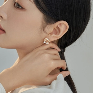 Elegant hollow floral wreath stud earrings with white pearls and gold finish for women