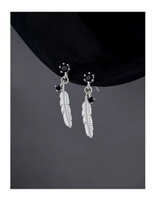 Detailed close-up of 925 sterling silver feather earrings with black zircon stones
