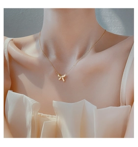 Detailed view of 925 silver bow necklace with micro-pave zircons on a model's collarbone