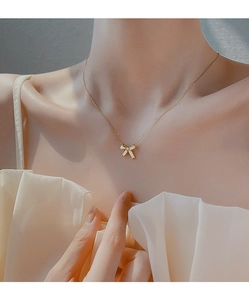 Detailed view of 925 silver golden bow necklace with pavé zircons on collarbone