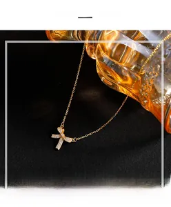 Macro shot of 925 silver gold bow necklace with sparkling zircons on textured background
