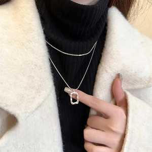 Close-up of double-layer gold geometric necklace with hammered rectangular pendant