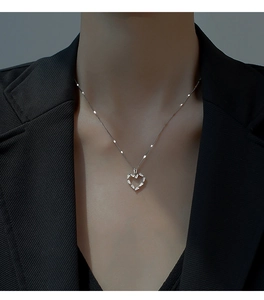 Détail du collier pendentif cœur évidé avec zircons baguette sur le cou d'un mannequin
