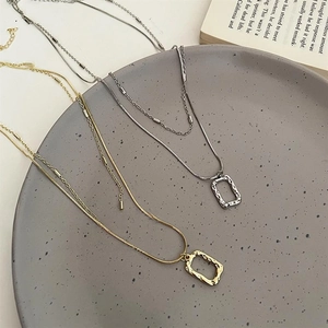 Detail of double-layer geometric necklace with rectangular hammered texture pendants