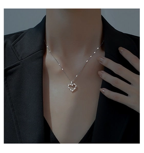 Mannequin portant un collier cœur évidé en argent 925 sur fond de costume sombre