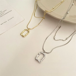 Detail of double-layer geometric rectangular pendant with hammered metal texture