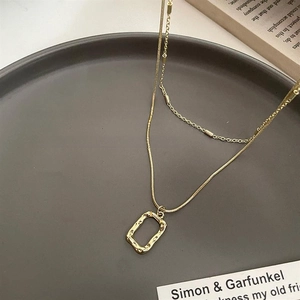 Close-up of double-layer gold snake chain with irregular rectangle texture pendant