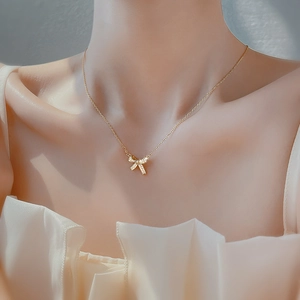 Elegant 925 silver bow necklace in gold with shimmering stones on a delicate chain