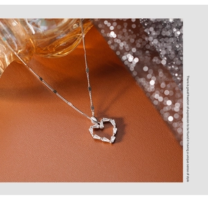 Détail du collier cœur évidé en argent 925 avec pierres baguette sur cuir marron luxueux