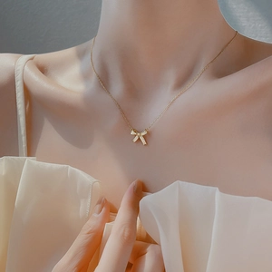 Elegant gold-plated 925 silver bow necklace with sparkling crystals worn by a model