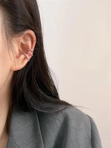 Close-up of minimalist silver ear bone clips with delicate pavé crystals for women