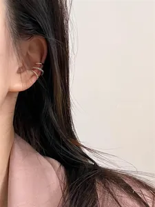 Three-piece set including gold ear cuff, zircon studded cuff and beaded hoop on a model