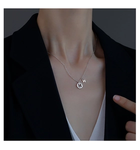 Gros plan du collier en argent S925 avec anneau en zircon brillant et pendentif lettre H