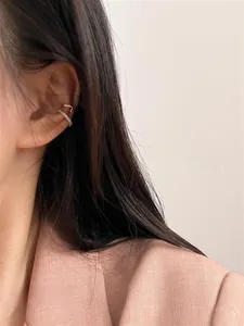 Close-up of elegant gold cuff earrings set with shimmering pavé micro-inlaid zircons