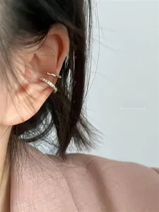 Close-up of double-layer gold ear cuff with white cubic zirconia on female model