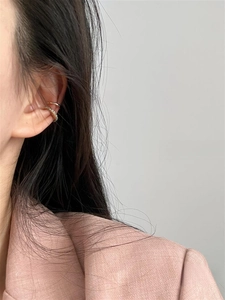 Close-up of double-layer gold ear cuff with shimmering pavé cubic zirconia on the ear bone