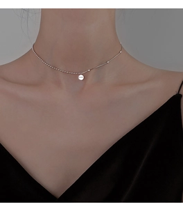 Detailed view of 925 sterling silver Lucky necklace with engraved round pendant on model