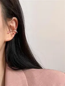Three-piece gold ear cuff set with rhinestones and polished textures on model's ear