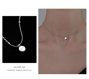 Detail of 925 sterling silver lucky pendant necklace with engraved lettering on flat chain