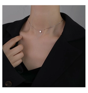 Close-up of minimalist 925 sterling silver beaded choker necklace on a model