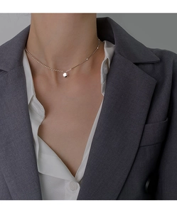 Close-up of minimalist 925 sterling silver bead chain necklace worn on a female model
