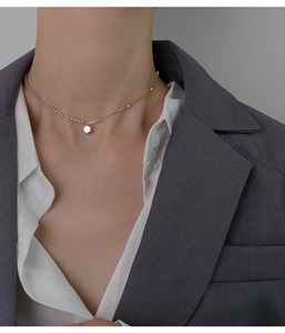 Detail of 925 sterling silver chain with a lucky pendant on a professional model