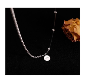 Detailed close-up of 925 silver beaded chain necklace with engraved lucky pendant tag