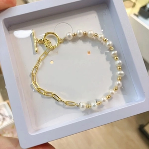Elegant half-pearl half-gold chain bracelet with OT toggle clasp in a jewelry box