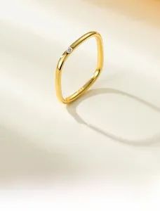 Detail of S925 sterling silver square ring in gold with a single clear round diamond