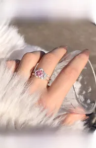 Close-up of s925 silver ring featuring a pink heart gem on a soft feather background