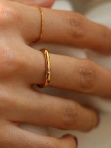Macro shot of gold minimalist rings with a centered fine diamond in French style