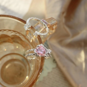 Detail of pink heart crystal ring with silver lava texture on an amber glass