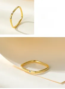 Macro detail of wave-shaped 925 silver ring with small crystal and premium gold plating