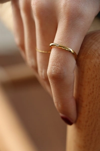 Macro shot of minimalist gold square ring with small diamond on model's finger