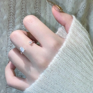 Macro view of adjustable silver ring with oval opal gemstone and zircon accent