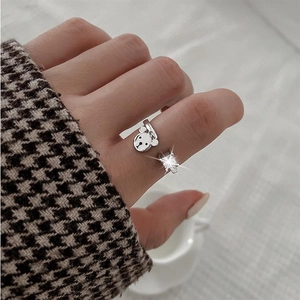 Close-up van een zilveren berenring met vierkante zirkoon aan vinger met gebreide trui