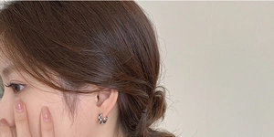 Gros plan de boucles d'oreilles damier noir et blanc sur l'oreille d'un mannequin