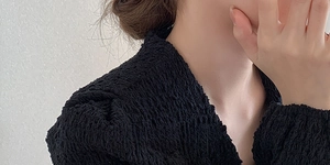 Gros plan du tissu texturé noir gaufré à bulles sur l'épaule d'un haut minimaliste