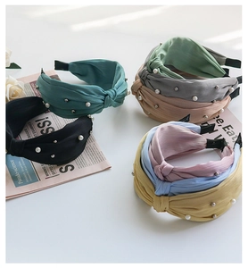 Detailed close-up of textured fabric headbands with elegant pearls and crystal accents