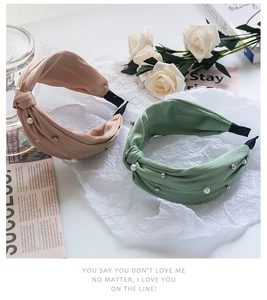Detail view of pink and green fabric knot headbands with elegant pearls and silver beads