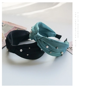 Detail of knotted fabric headbands in black and teal with pearl and bead embellishments