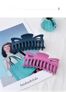 Matte finish large hair claw clips in navy blue and peach pink on stylish background